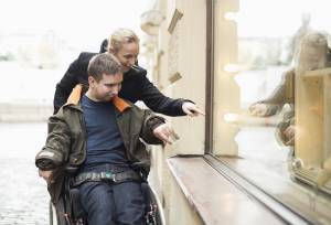 A caregiver and a man in wheelchair window shopping