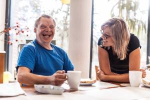 Man with IDD and caregiver enjoying coffee